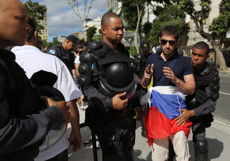 Riot policemen search a soccer fan wearing Russia's team colors as he arrives to Maracana stadium  for the group H World Cup match between Belgium and Russia, in Rio de Janeiro, Brazil, Sunday, June 22, 2014. (AP Photo/Leo Correa)