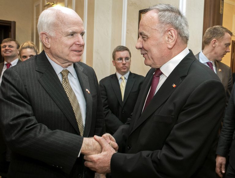 US Senator John McCain, left, shakes hands with Moldova's President Nicolae Timofti, right, in Chisinau, Moldova, Thursday, April 17, 2014. McCain warned of tougher sanctions against Russia if it did not cease fomenting unrest in the region, while Russian President Vladimir Putin urged Ukraine to end a blockade of Moldova's separatist province Trans-Dniester. (AP Photo)