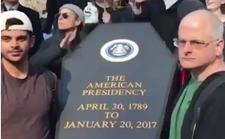A few of the demonstrators held up a prop tomb stone that read: 