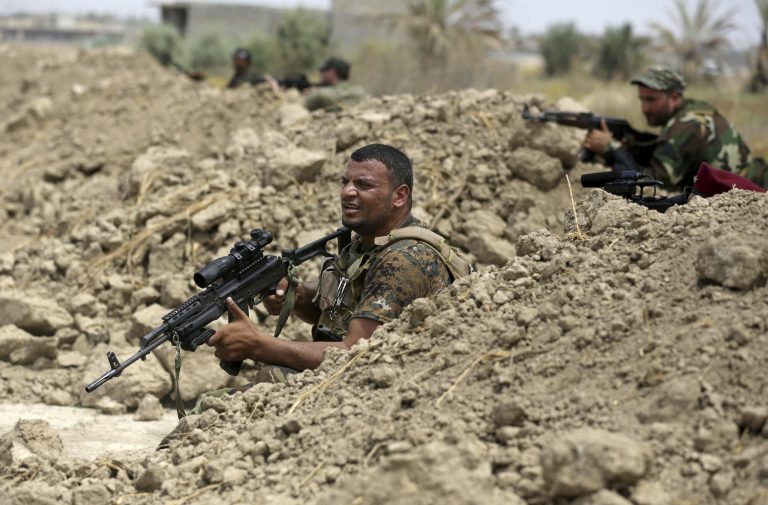 Iraq Shiite fighters hold their weapons during clashes with militants from the extremist Islamic State group in Jurf al-Sakhar, Iraq, on Monday. (AP/Hadi Mizban)