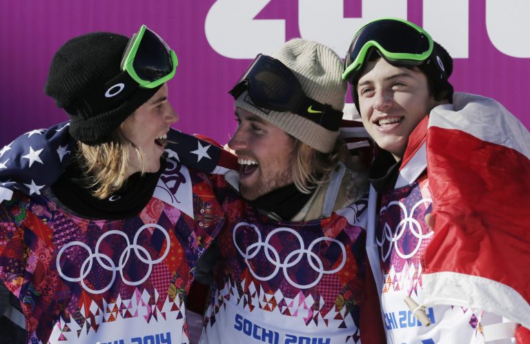 United States' Sage Kotsenburg, center, celebrates with  Norway's Staale Sandbech, left, and Canada's Mark McMorris after Kotsenburg won the men's  snowboard slopestyle final at the Rosa Khutor Extreme Park, at the 2014 Winter Olympics, Saturday, Feb. 8, 2014, in Krasnaya Polyana, Russia. Sandbech took the silver medal and McMorris took bronze. (AP Photo/Andy Wong)