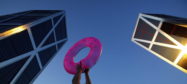   FILE - In this June 16, 2012 file photo, a demonstrator holds a life saver in front of the headquarters of Bankia bank during a protest against the Spanish bank in Madrid.Spain's economy ministry says euro 39.5 billion ($51.3 billion) in bailout aid approved by European authorities for troubled Spanish banks has arrived. A ministry spokeswoman said Wednesday Dec. 12, 2012 the money is now in the hands of a state-run fund set up to help those entities worst hit by the property market collapse in 2008. The funds are part of a euro 100 billion rescue package earmarked for Spain by the other 16 European Union countries that use the euro. The package is designed to ease the pressure on the government so it can concentrate on managing national finances and avoid a full-blown sovereign bailout. (AP Photo/Andres Kudacki, File)  