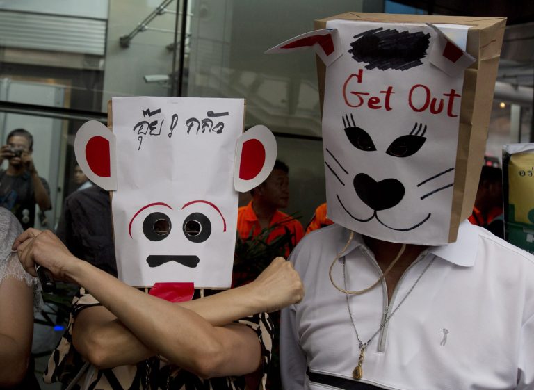 Protesters wear masks during an anti-coup demonstration in Bangkok, Thailand Sunday, June 1, 2014. Hundreds of demonstrators shouting 