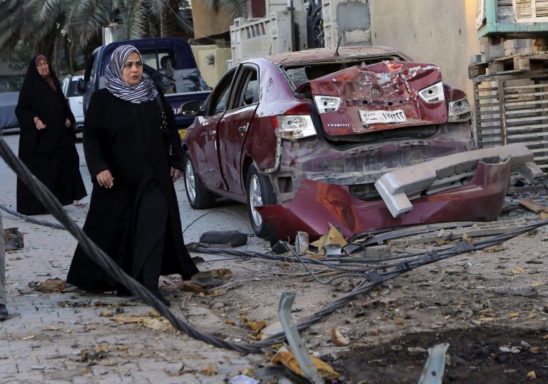 FILE - In this file photo taken on Oct. 8, 2013, women walk past the aftermath of a car bomb attack in the mainly Shiite neighborhood of Zafaraniyah in southeastern Baghdad, Iraq. The wave of attacks by al-Qaida and Sunni extremists that has killed thousands of Iraqis in 2013 so far, most of them Shiites, is provoking ominous calls from Shiite leaders to take up arms in self-defense. IraqÃ?s Shiite prime minister, Nouri al-Maliki, who will meet with U.S. President Barack Obama on Friday, Nov. 1, 2013, said he wants American help in quelling the violence. (AP Photo/Hadi Mizban, File)