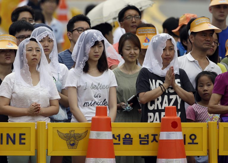 Catholic faithful pray during a mass and the beatification of Paul Yun ji-Chung and 123 martyr companions celebrated by Pope Francis at Gwanghwamun Gate in Seoul, South Korea, Saturday, Aug. 16, 2014. Paul Yun Ji-Chung who was born in 1759 was among the earliest Catholics on the peninsula. (AP Photo/Gregorio Borgia)