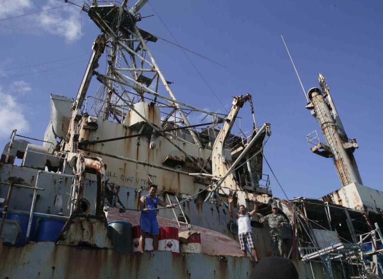 Fresh batch of Philippine Marines wave goodbye to the departing government vessel AM700 to begin their deployment on the dilapidated navy ship LT 57 BRP Sierra Madre at the disputed Second Thomas Shoal, locally known as Ayungin Shoal, Sunday, March 30, 2014 off the South China Sea. On Saturday, China Coast Guard attempted to block the Philippine government vessel AM700 carrying fresh troops and supplies, but the latter successfully managed to dock beside the ship to replace troops who were deployed for five months. (AP Photo/Bullit Marquez)