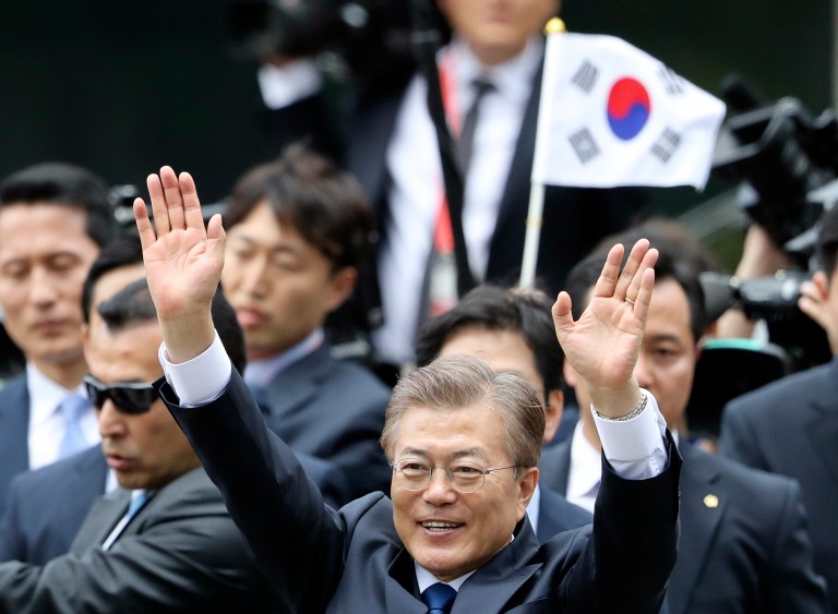 South Korea's new President Moon Jae-in waves to neighborhoods and supporters upon his arrival at outside of the presidential Blue House in Seoul, South Korea, Wednesday, May 10, 2017. Moon said Wednesday he was open to visiting rival North Korea under the right conditions to talk about Pyongyang's aggressive pursuit of nuclear-tipped missiles. (AP Photo/Lee Jin-man)