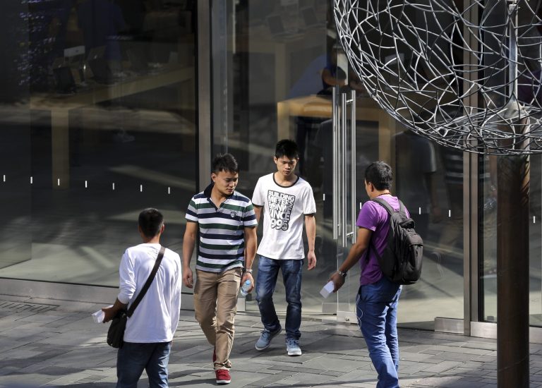 Scalpers try to offer resale of iPhone 6 and iPhone 6 Plus devices to people walking out from an Apple Store in Beijing, China Wednesday, Sept. 24, 2014. Apple's iPhone 6 has yet to arrive in China, the world's most populous country. Apple said it sold more than 10 million of the new two models in their first three days on sale. (AP Photo/Andy Wong)