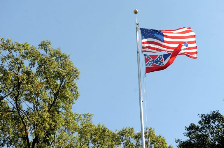 The Mississippi state flag and U.S. flag fly in the Circle on campus at the University of Mississippi in Oxford, Miss. The state flag was removed Monday. (Bruce Newman/Oxford Eagle via AP)
