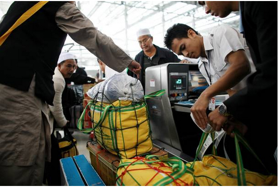 Thai muslim pilgrims weigh their lugguage at Suvarnabhumi airport on November 30, 2008 in Bangkok, Thailand. (Photo by Chumsak Kanoknan/Getty images)