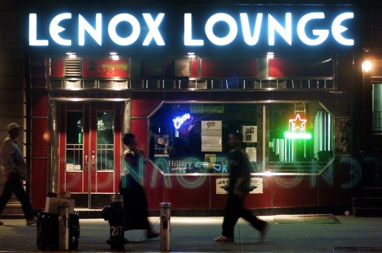   FILE - In this Oct. 19, 2000 file photo, pedestrians pass by the Lenox Lounge in the Harlem neighborhood of New York. Longtime owner Alvin Reed says that the Harlem cabaret with a supercool, Art Deco style that made it a favorite of jazz greats like Billie Holiday, Miles Davis and John Coltrane, is closing its doors on New Year's Eve. (AP Photo/Suzanne Plunkett, File)  