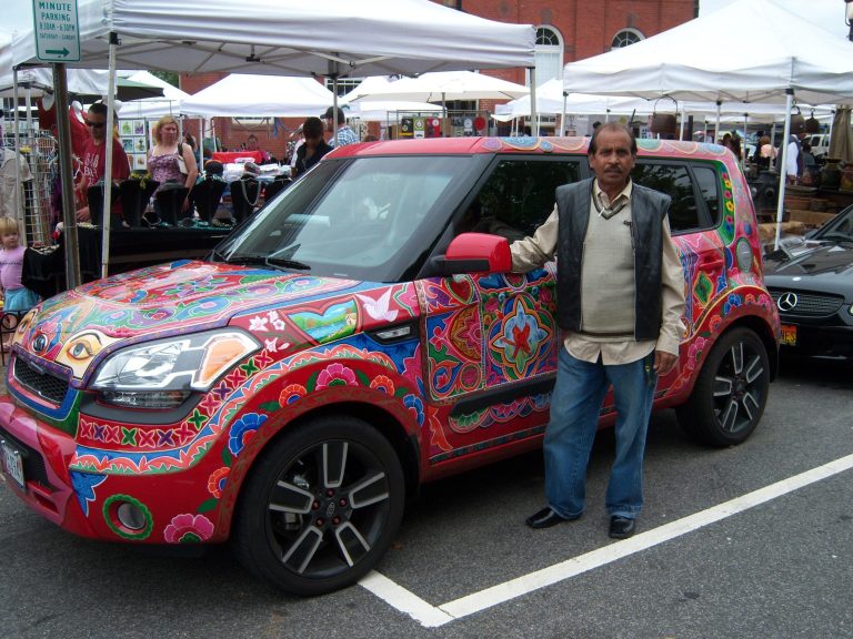 Ghulam Sarwar stands with a Kia he hand-painted. Originally from Peshawar, a war-torn region near the Khyber Pass, he has been painting vehicles ? and furniture ? here in the U.S. recently, livening up Washington's traffic jams.