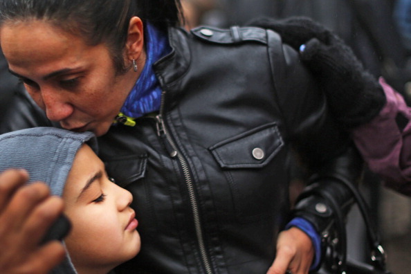NEWTOWN, CT - DECEMBER 16:  Ty Diaz is kissed by his mother Yvette at a memorial down the street from the Sandy Hook School December 16, 2012 in Newtown, Connecticut. Twenty-six people were shot dead, including twenty children, after a gunman identified as Adam Lanza opened fire at Sandy Hook Elementary School. Lanza also reportedly had committed suicide at the scene. A 28th person, believed to be Nancy Lanza, found dead in a house in town, was also believed to have been shot by Adam Lanza.  (Photo by Spencer Platt/Getty Images)