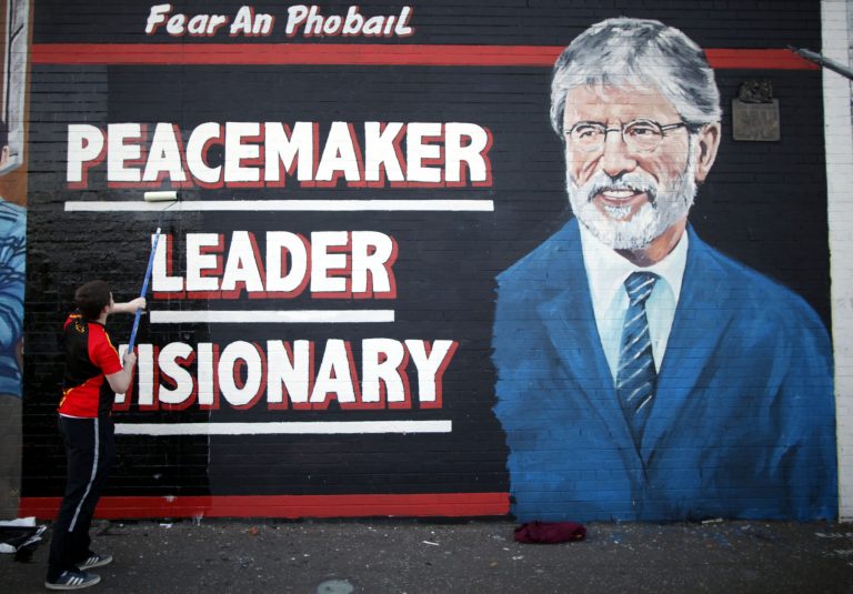 A man adds the finishing touch to a newly painted mural of Gerry Adams on the Falls Road, West Belfast, Northern Ireland, Northern Ireland, Friday, May, 2 2014.  Police continue to question the Sinn Fein leader Gerry Adams at Antrim police station about the 1972 murder of Jean McConville.  (AP Photo/Peter Morrison)