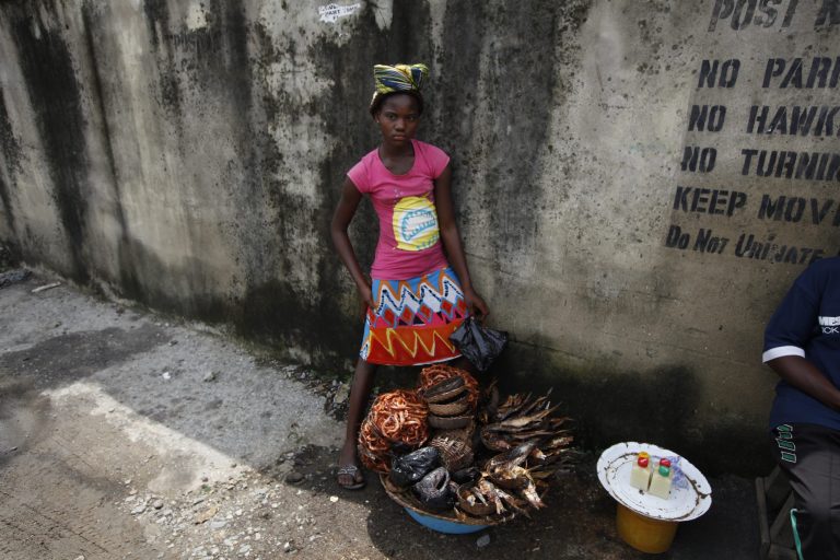 Twelve-year-old, Kemi Olajuwon, who has to drop out of school some days to sell smoked fish and make money so there can be food in the house, and also for her school fees, displays her fish on the street in the Obalende area of Lagos, Nigeria, Tuesday, June 17, 2014. About 30 million primary school-aged children in sub-Saharan Africa are not in class, partially because of conflict and poverty, and progress to get them back to school has stalled, two U.N. agencies said. The situation is especially dire in West and Central Africa, which has the largest proportion of children out of school of any region in the world, said a pair of reports published Monday by UNICEF, the U.N. children's agency, and the statistics arm of UNESCO, the U.N. cultural and education agency. (AP Photo/Sunday Alamba)