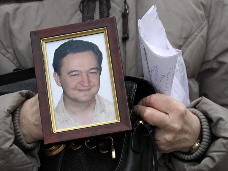 FILE - In this Nov. 30, 2009 file photo, Nataliya Magnitskaya holds a portrait of her son, Russian lawyer Sergei Magnitsky, a lawyer who died in jail, as she speaks with The Associated Press in Moscow, Russia. The Treasury Department on Friday announced the names of 18 Russians subject to financial sanctions and visa bans because of their alleged violations of human rights. The list, an outgrowth of a law enacted last December to hold Russian officials accountable for human rights abuses, is certain to further strain relations with the Moscow government. Russia has strongly objected to the act and threatened to retaliate with its own sanctions. The act is named for Magnitsky, who was arrested in 2008 for tax evasion after accusing Russian police officials of stealing $230 million in tax rebates. He died in prison the next year, allegedly after being beaten and denied medical treatment. (AP Photo/Alexander Zemlianichenko, File)