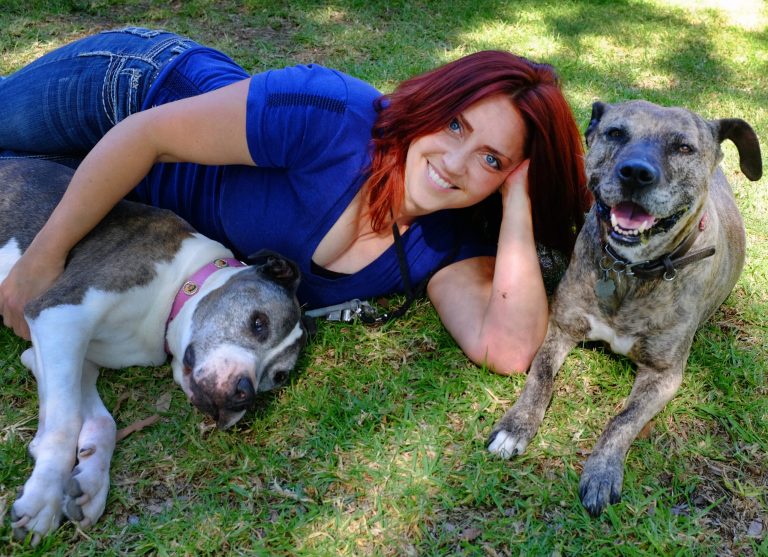 This Friday, May 2, 2014 photo Lori Fusaro sits with Sunny, right an 18 year old Pit Bull and Gabi, 11, in the Culver City section of Los Angeles. Fusaro is set to publish a book called 