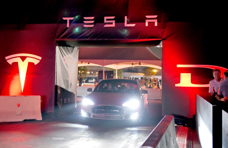 Owners take a ride in a new Tesla sedan. The electric carmaker's board has formed a special committee to review founder Elon Musk's proposal to take the business private. 