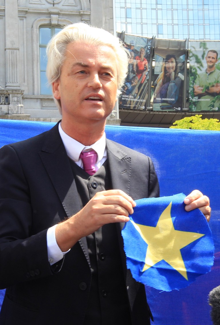 Dutch populist and euro-sceptic Geert Wilders shows a yellow star he cut out of the EU flag in front of the European Parliament in Brussels, Tuesday, May 20, 2014. Wilders is campaigning on a platform forbidding any further transfer of power to Europe, scrapping the Euro and control of immigration policy. (AP Photo/Yves Logghe)