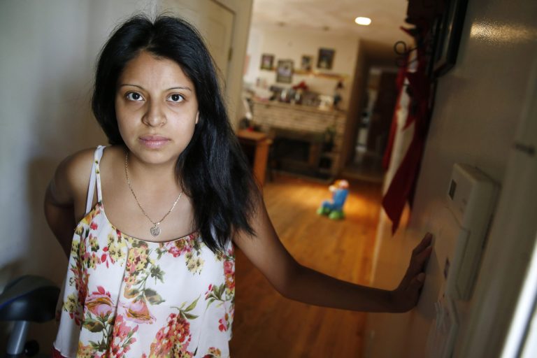 Lorena Lopez stands in the doorway at her aunt's house as she poses for a portrait in Lynn, Mass. Lopez, a student at Lynn English High School, crossed the border from Guatemala without her family almost four years ago. (AP Photo/Michael Dwyer, File)