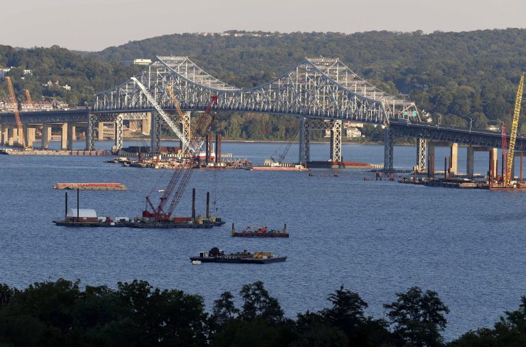In this Sept. 18, 2014 photo, construction equipment is positioned near the Tappan Zee Bridge as seen from Nyack, N.Y. With a price tag of $3.9B, the new Tappan Zee Bridge is one of the most expensive public works projects in U.S. history, yet New York Gov. Andrew Cuomo hasn't said how high tolls will have to be to pay for it. (AP Photo/Seth Wenig)