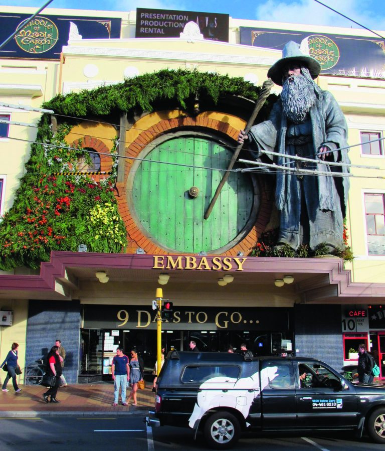 People walk by the Embassy Theater where a giant statue of the character Gandalf from the upcoming movie 