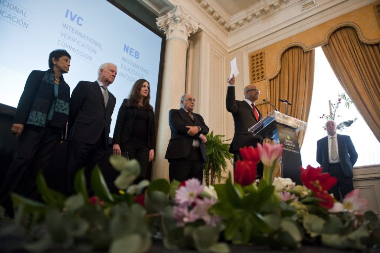 Ram Manikkalingam, a member of the commission overseeing the Basque group ETA's ceasefire, announced in 2011, second right, shows a document from ETA after the armed group announced the first step in disarmament, putting some weapons and explosives out of use, in Bilbao northern Spain, Friday, Feb. 21, 2014. ETA is blamed for killing some 830 people between the late 1960s in bombings and its 2011 cease-fire in a campaign for a Basque homeland in northern Spain and southwest France. (AP Photo/Alvaro Barrientos)