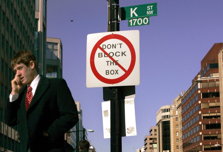 A pedestrian talks on his mobile phone as he crosses K Street in Washington. (AP Photo/Charles Dharapak, File)