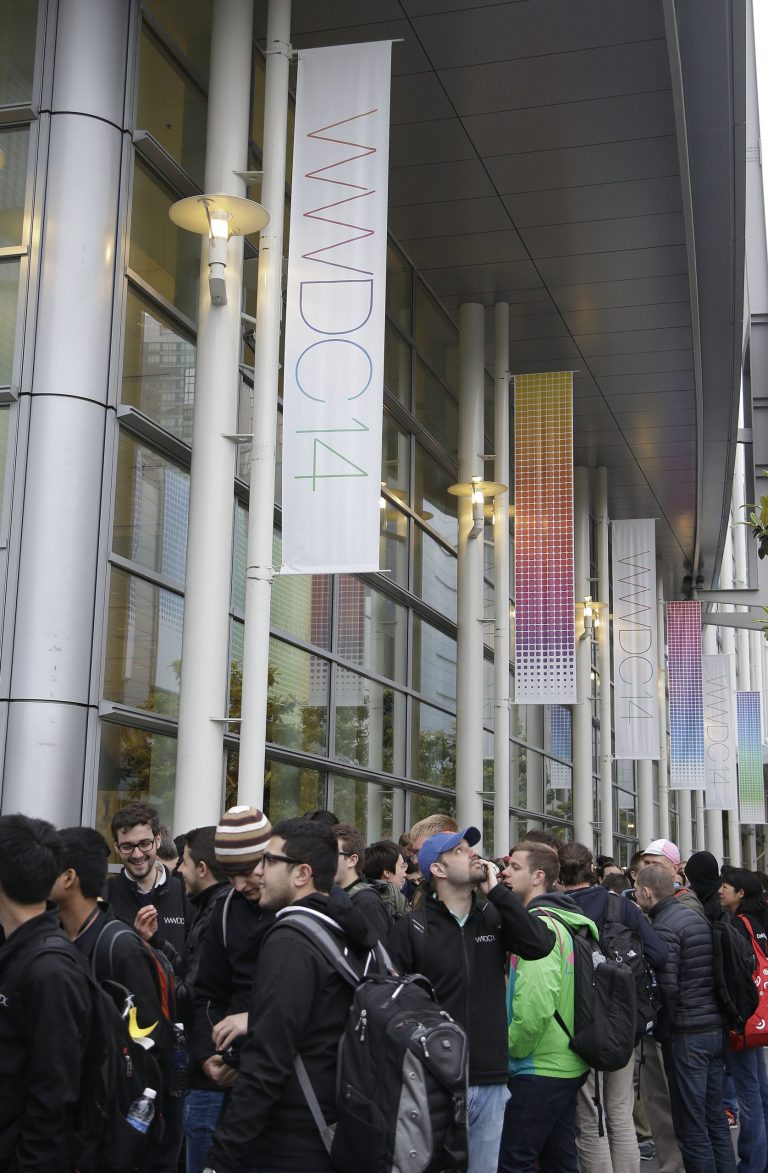 A crowd lines up before the Apple World Wide Developers Conference 2014 at the Moscone Center in San Francisco, Monday, June 2, 2014. This week should provide a better sense of whether Apple is heading down promising new avenues of growth or whether it's still wandering aimlessly around well-trod territory in search of another breakthrough. (AP Photo/Jeff Chiu)