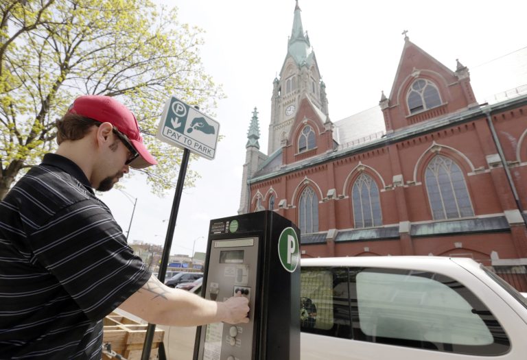 Kyle Vocelka buys some time for his vehicle from a Chicago parking meter kiosk across the street from St. Alphonsus Catholic Church on Chicago's north side. In December 2008, Chicago entered into a 75-year deal with a private company for control of its 36,000 parking meters in return for $1.15 billion.The deal was rushed through politically, and the city's inspector general estimated that government underpriced the value of the meters by about $1 billion. (AP Photo/M. Spencer Green)