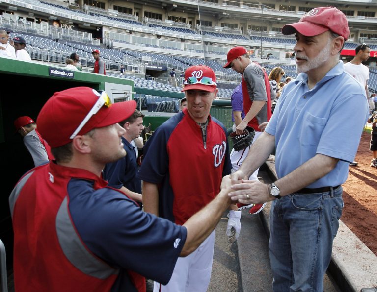   FILE - This Sept. 7, 2012 file photo shows Washington Nationals third baseman Ryan Zimmerman, left, and first baseman Adam LaRoche, center, greeting Federal Reserve Board Chairman Ben Bernanke before a baseball game against the Miami Marlins at Nationals Park in Washington. Other ballclubs may stake the claim to âAmericaâs team,â but when it comes to the nationâs ruling class, itâs the Washington Nationals in a landslide. On their way to Washingtonâs first postseason baseball appearance since 1933, the Nationals last year won the affection of many national politicians, policymakers and pundits. (AP Photo/Alex Brandon, File)  