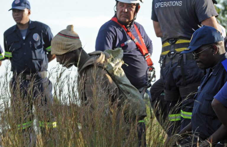 A trapped illegal miner at a disused gold mine shaft near, Benoni, South Africa, is bought to the surface Sunday, Feb. 16, 2014. Debris trapped a group of miners who were working illegally in an abandoned mine in South Africa, but rescue workers cleared the mine shaft entrance and at least 11 miners were escorted to safety  Some of the miners still below the surface in the gold mine shaft near Johannesburg appeared to be reluctant to emerge because of fears they would be arrested (AP Photo)