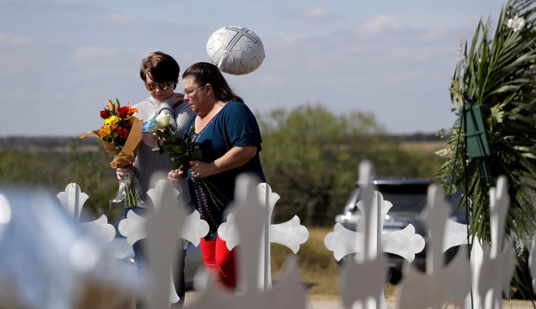 Randi Ray Rivera, left, and Belenda McLauren, right, visit a makeshift memorial near the scene of a shooting at the First Baptist Church of Sutherland Springs, Tuesday, Nov. 7, 2017, in Sutherland Springs, Texas. A man opened fire inside the church in the small South Texas community on Sunday, killing more than two dozen and wounding others. (AP Photo/Eric Gay)