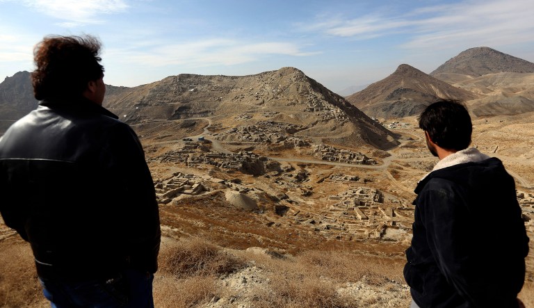 FILE - In this Sunday, Jan. 18, 2015, file photo, Abdul Qadir Timor, director of archaeology at the Ministry of Information and Culture, left, looks at the view of Mes Aynak valley, some 40 kilometers (25 miles) southwest of Kabul, Afghanistan. The Afghan government is trying to grab President Donald Trump's attention by dangling its massive, untouched wealth of minerals, including lithium, the silvery metal used in mobile phone and computer batteries considered essential to modern life. But tapping into that wealth, which also includes coal, copper, rare earths and far more, is likely a long way off, with security worsening the past year and Trump's policy on the war still not known. (AP Photo/Rahmat Gul, file)