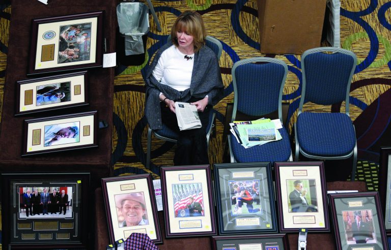 FILE - This Feb. 24, 2012 file photo shows Kay Aaron waiting for customers at a booth selling pictures of Republican leaders and icons during the California Republican Party convention in Burlingame, Calif. If the future happens first in California, the Republican Party has a problem. The nation's most populous state _ home to one in eight Americans _ has entered a period of Democratic political dominance so far-reaching that the dwindling number of Republicans in the Legislature are in danger of becoming mere spectators at the statehouse. (AP Photo/Marcio Jose Sanchez, File)