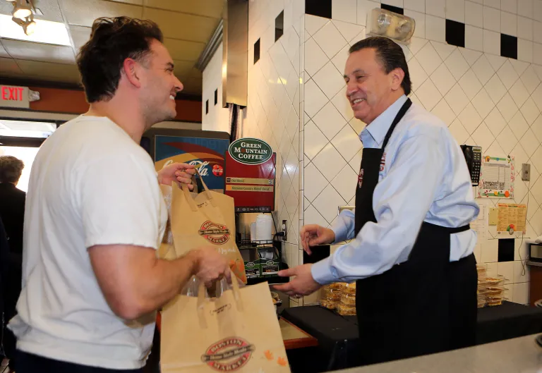   This Nov. 22, 2012 photo provided by Boston Market shows Boston Market CEO George Michel, right, working inside a company's Miami-area restaurant on the home style restaurant chains busiest day of the year, Thanksgiving, in Miami. Boston Market Corp. is reporting record Thanksgiving sales this year, and it's already planning for next Thanksgiving. The Golden, Colo.-based restaurant chain had not yet released specific dollar figures but said total sales per restaurant from Nov. 19 to Nov. 23 were up 13 percent from a comparable period last year. (AP Photo/Boston Market, Marc Serota)  