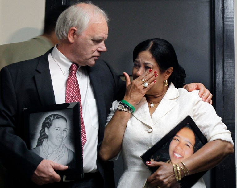   Nicolas and Virginia Payne, of New Milford, Conn., react as they hold pictures of their slain daughter, Rebecca, outside a Suffolk Superior Courtroom in Boston, Monday, June 18, 2012, after Cornell Smith, 30, was arraigned on first-degree murder charges in her shooting death in her Boston apartment. (AP Photo/Elise Amendola)  