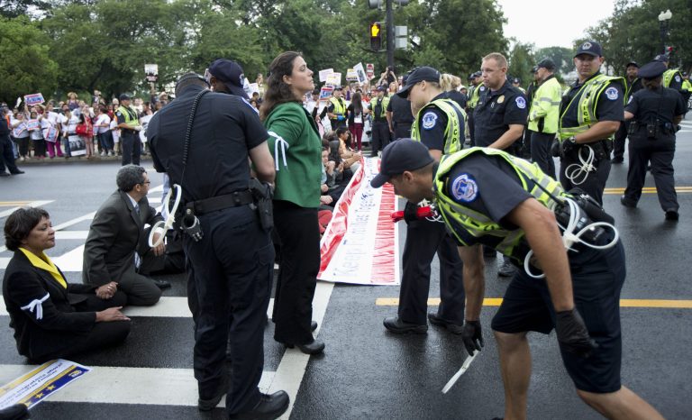   Capitol Hill police officers arrest immigration reform protestors as they blocked a street on Capitol Hill in Washington, Thursday, Aug. 1, 2013. (AP Photo/Manuel Balce Ceneta)  