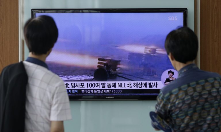 People watch a TV news program reporting on North Korea's artillery shells at Seoul Railway Station in Seoul, South Korea, Monday, July 14, 2014. North Korea on Monday fired artillery shells into waters near its sea border with South Korea, Seoul's military said, a day after the country test-launched two ballistic missiles in the latest of a series of weapon tests.  The superimposed letters on the screen read: 