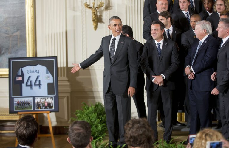 President Barack Obama points to a framed team jersey that was given to him by the members of the Sporting Kansas City soccer team during a ceremony in the East Room of the White House in Washington, Wednesday, Oct. 1, 2014, where he honored the 2013 Major League Soccer champions. (AP Photo/Pablo Martinez Monsivais)