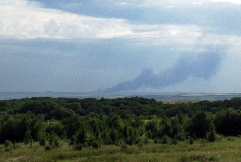 FILE - In this Thursday, July 17, 2014 mobile phone photo provided by Andrei Kashtanov, smoke rises from the site where a Malaysia Airlines commercial plane went down in eastern Ukraine. All 298 people aboard the Boeing 777 traveling from Amsterdam to Kuala Lumpur were killed. (AP Photo/Andrei Kashtanov)