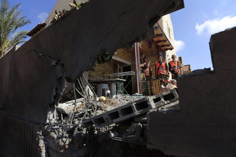 Israeli soldiers stand at a damaged home after a rocket  fired by Palestinian militants in Gaza, landed in the southern town of Sderot Thursday, July 3,2014. Israeli military carried out airstrikes on the Gaza Strip after Palestinian militants fired rockets into Israel early Thursday. The Israeli military said the air force struck 15 