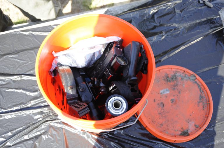   This undated photo provided by the FBI shows a Home Depot bucket containing gun parts, ammunition and other items discovered at a Parishville, N.Y. reservoir after a man jailed in Alaska admitted to a series of killings, including an Anchorage barista and a couple from Vermont. (AP Photo/FBI)  