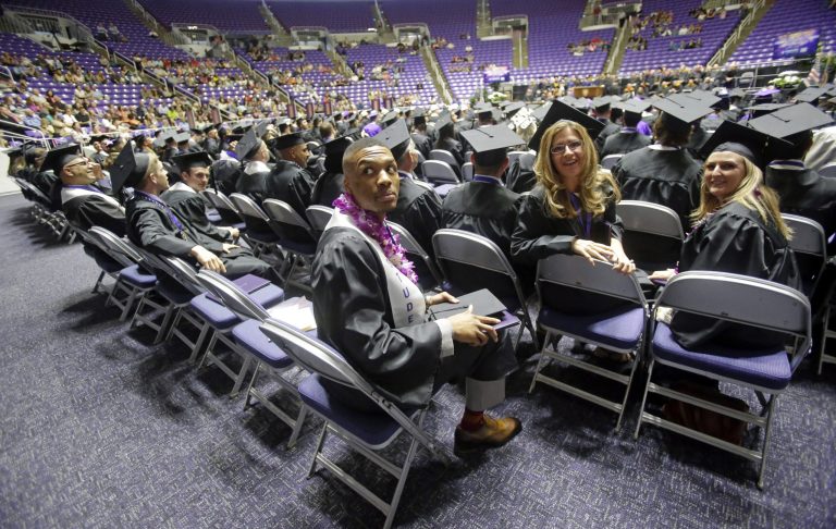 Portland Trail Blazers point guard Damian Lillard, center, looks on during commencement exercises at Weber State Friday, May 1, 2015, in Ogden, Utah. (AP Photo/Rick Bowmer)