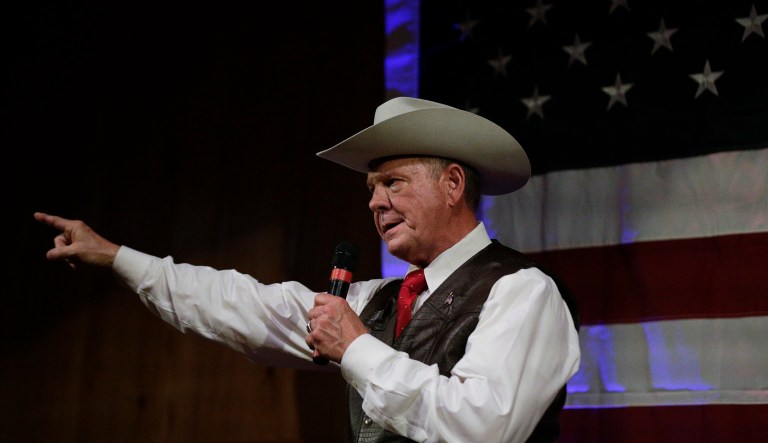Former Alabama Chief Justice and U.S. Senate candidate Roy Moore speaks at a rally in Fairhope, Ala. A congregation of about 250 stands on the mulched barnyard floor and listens intently to the sweaty political service on stage. (AP Photo/Brynn Anderson)
