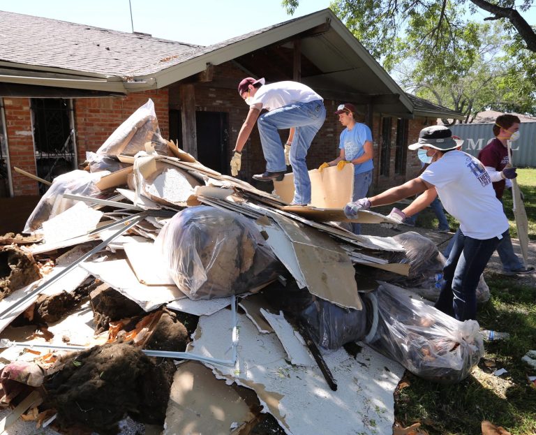 Texas A&M students clean debris at a home in West, Texas, Saturday, May 4, 2013, that was damaged due to the explosion at a fertilizer plant in West on April 17. The plant that exploded, killing 14 people, injuring more than 200 others and causing tens of millions of dollars in damage to the surrounding area, had only $1 million in liability coverage, lawyers said Saturday. (AP Photo/Waco Tribune Herald, Rod Aydelotte)