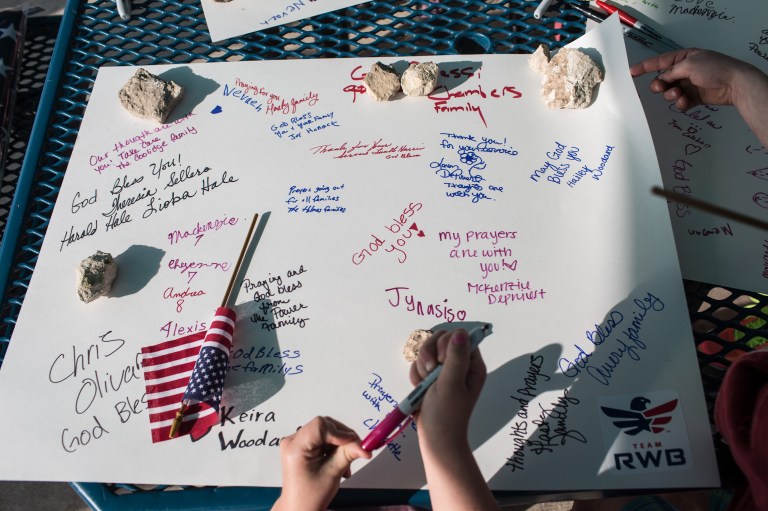 Active members of the military, veterans and civilians sign posters at Lions Club Park that will be delivered to the families of the victims affected by the Fort Hood shooting tragedy, on Friday, April 4, 2014, in Killeen, Texas. On April 2, three people were killed and 16 were wounded when a gunman opened fire before taking his own life at the Fort Hood military base. (AP Photo/Tamir Kalifa)