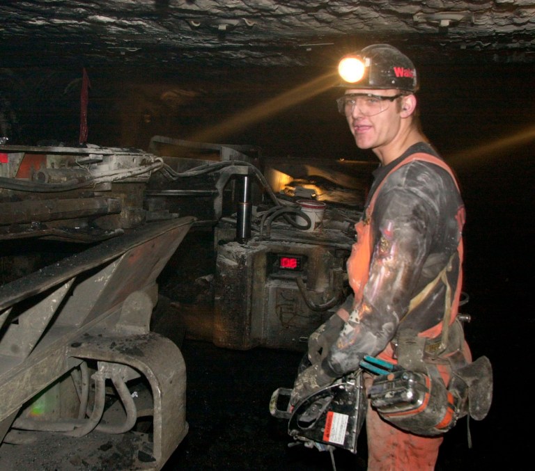 Standing beside a 40-ton continuous mining machine, coal miner Ron Bryant Jr. uses a waist-level remote control to cut coal more than 450 feet underground at the American Coal Company's Galatia Mine in Galatia, Ill. Thursday, Feb. 21, 2002. (AP Photo/Charles Rex Arbogast)