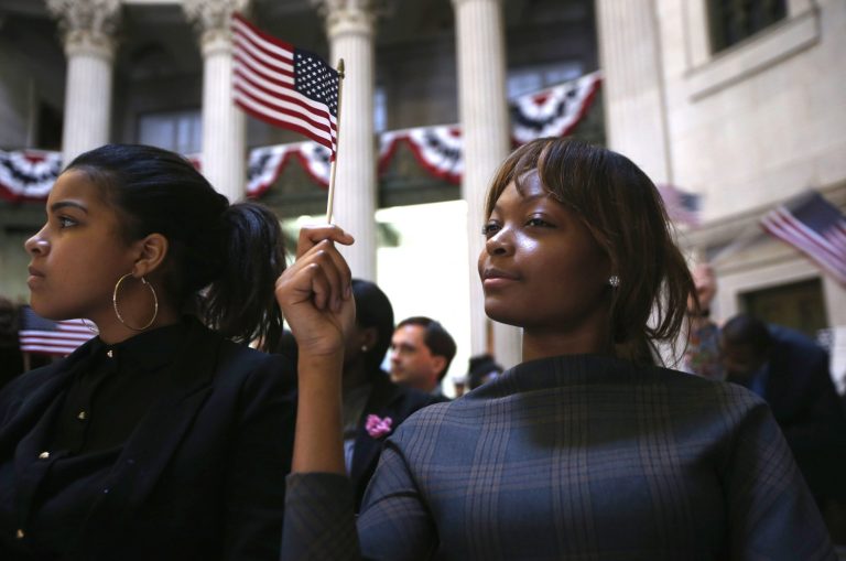 NEW YORK, NY - MARCH 22:  Immigrants wave U.S. flags after becoming American citizens at a naturalization ceremony at Federal Hall on March 22, 2013 in New York City. Seventy-four immigrants from 39 different countries took part in the event held in the historic building where George Washington took the oath of office as the first President of the United States. The event was held by U.S. Immigrant and Citizenship Services (USCIS).  (Photo by John Moore/Getty Images)