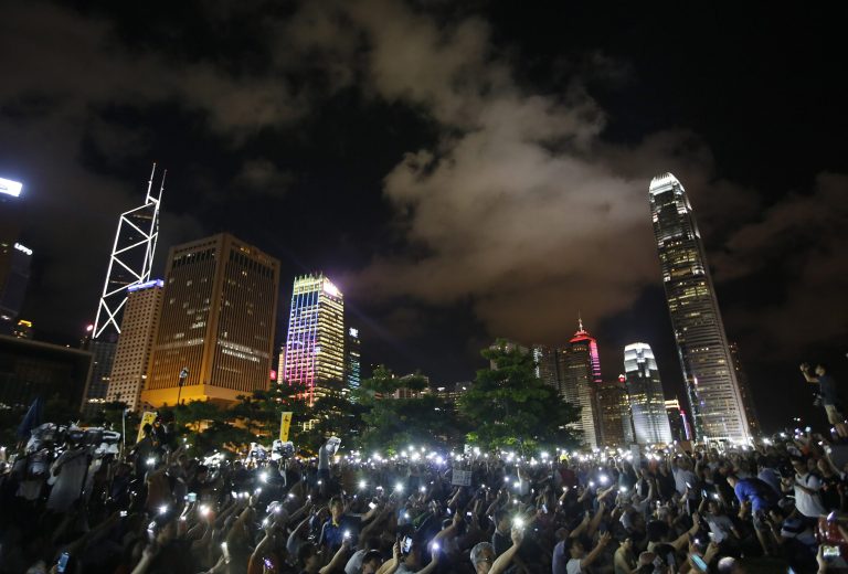 Protesters wave their mobile phones during a rally, after China's legislature has ruled out open nominations in elections for Hong Kong's leader in Hong Kong, Sunday, Aug. 31, 2014. China's legislature's standing committee announced Sunday that all candidates must receive more than half of votes from a special nominating body before going before voters. (AP Photo/Vincent Yu)